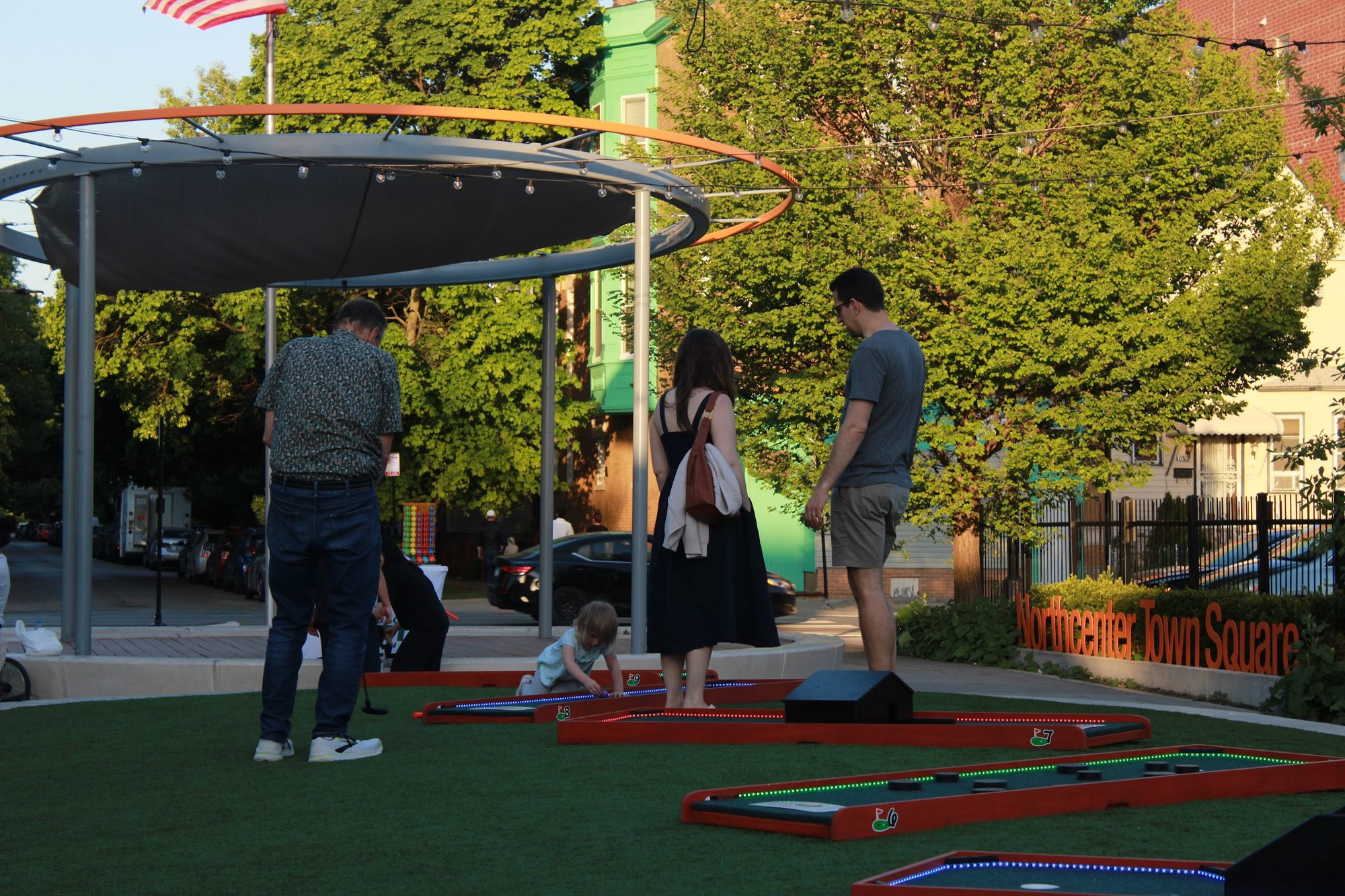 An evening mini golf event in a neighborhood plaza
