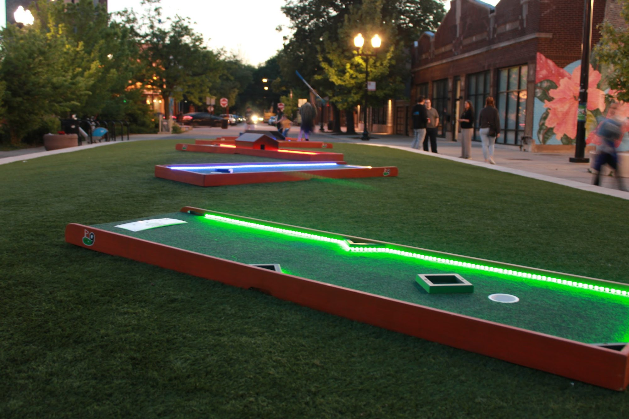 LED mini golf holes glowing green at night