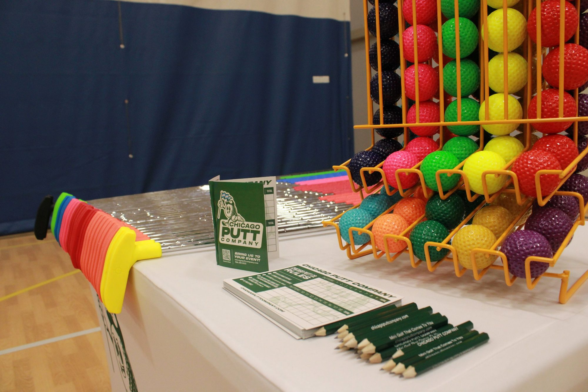 Racks of colorful putters and golf balls ready for players